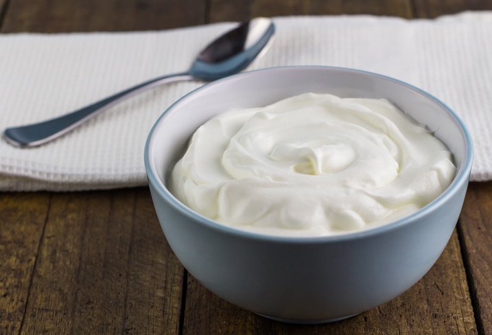 Natural creamy Greek yoghurt on wooden table background