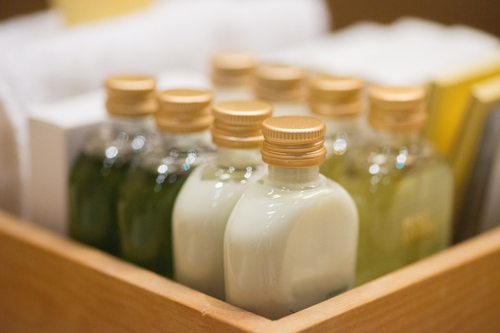 small shampoo bottles in wodden basket in hotel room