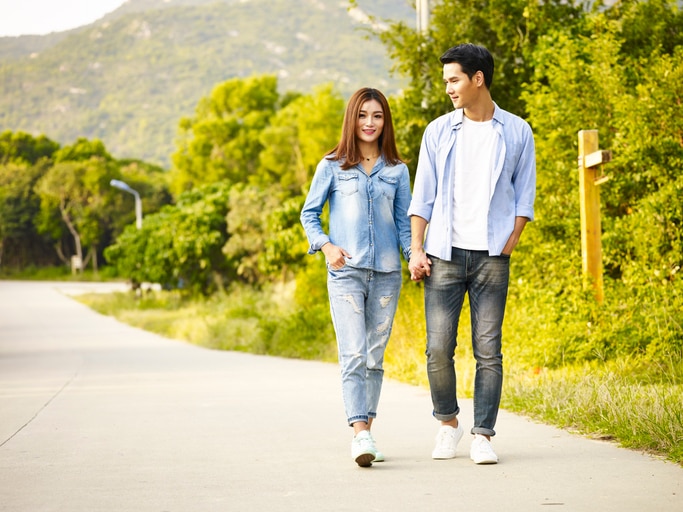 young asian couple walking on rural road, hand in hand.