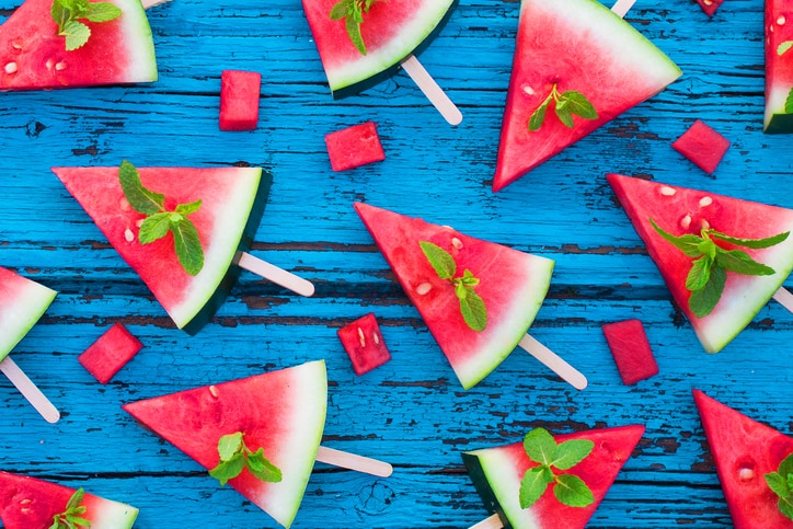 Watermelon pattern. Sliced watermelon  popsicles on  blue rustic wooden background. Flat lay. Tropical Summer idea