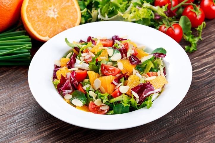 Fresh Orange, vegetables salad. on wooden table