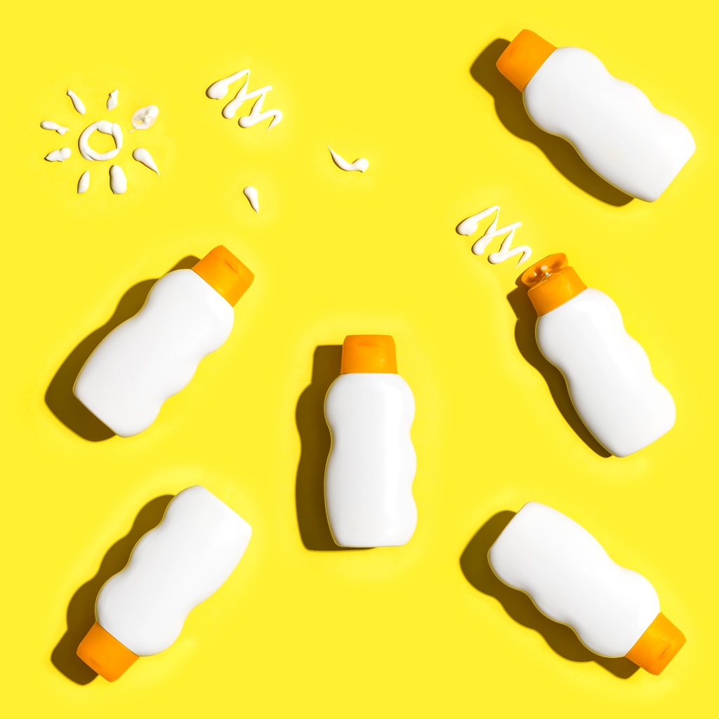 Sunscreen bottles arranged on a bright yellow background