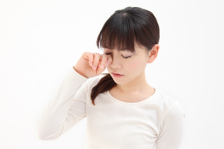 Young Asian woman touch the eye white background