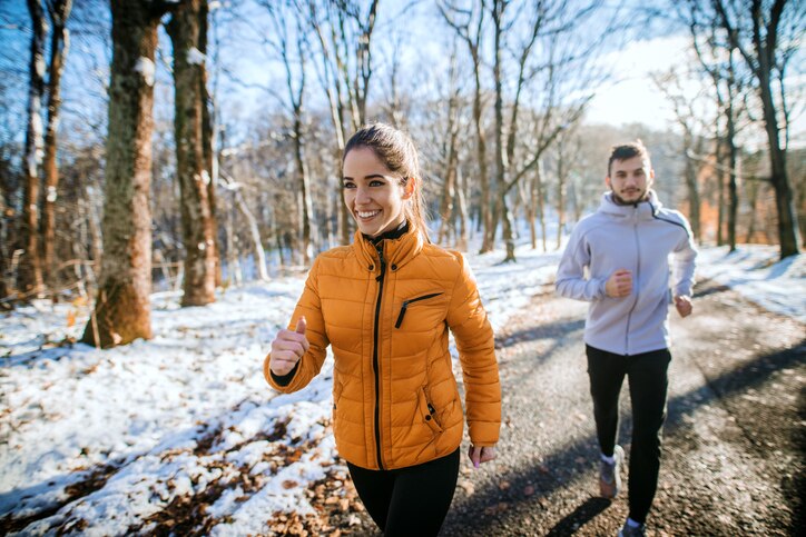 Fitness couple winter morning exercise at snowy mountain.