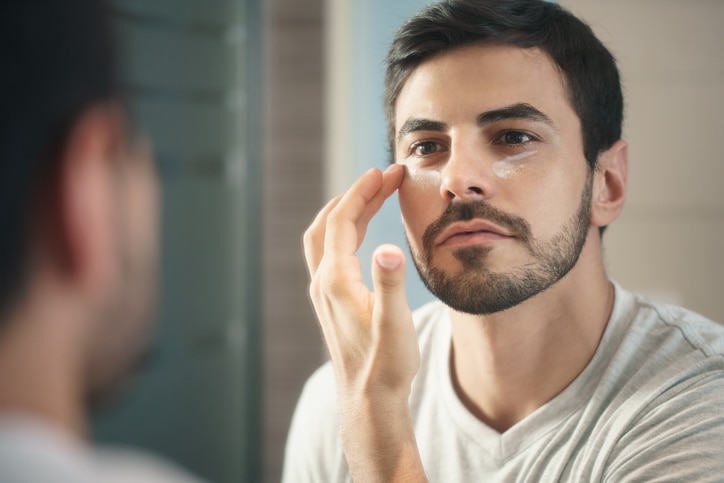 Woman putting face cream on husbands face