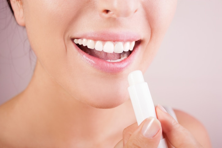 woman applying balsam on lips