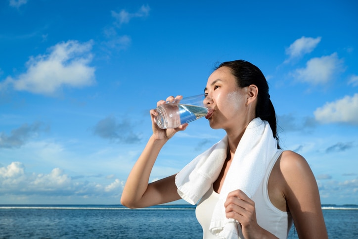 A woman is drink water after fitness