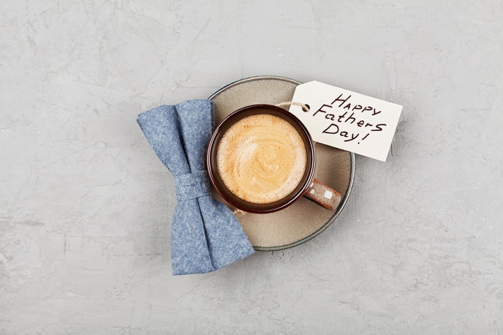 Morning cup of coffee and bowtie on stone desk top view in flat lay style for breakfast on Happy Fathers Day.