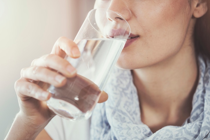 Young woman drinking pure glass of water