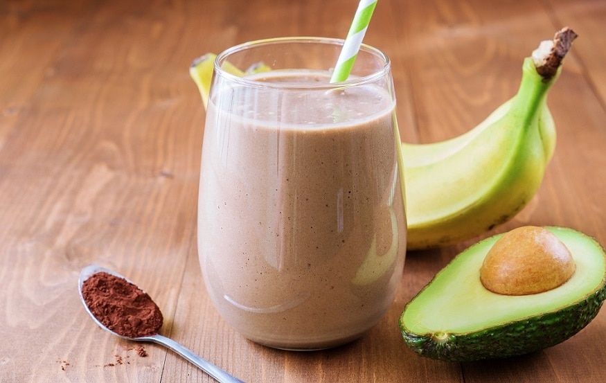 Healthy chocolate avocado banana smoothie on wooden background