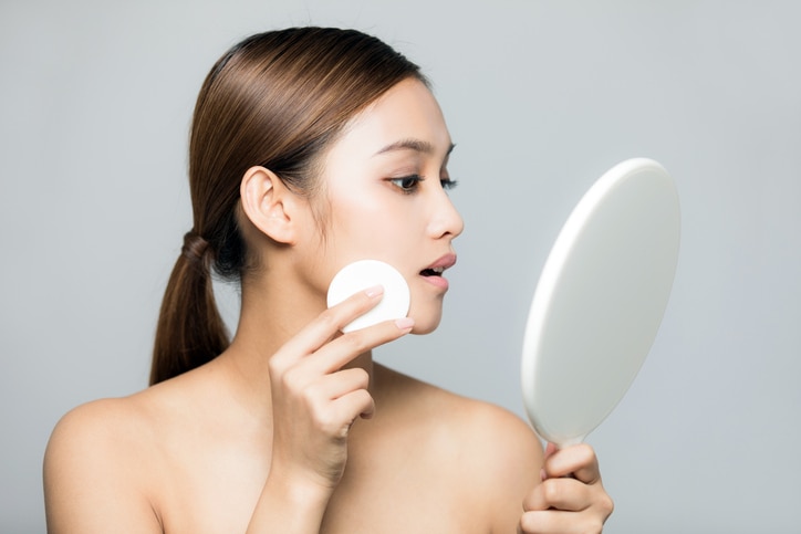 Young woman doing makeup. Skin care concept.