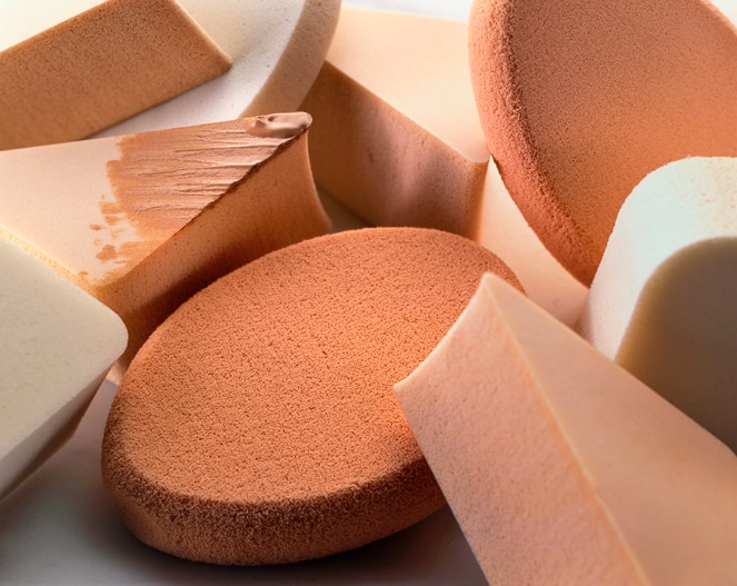 close up on heap of make-up sponges with foundation and face powder