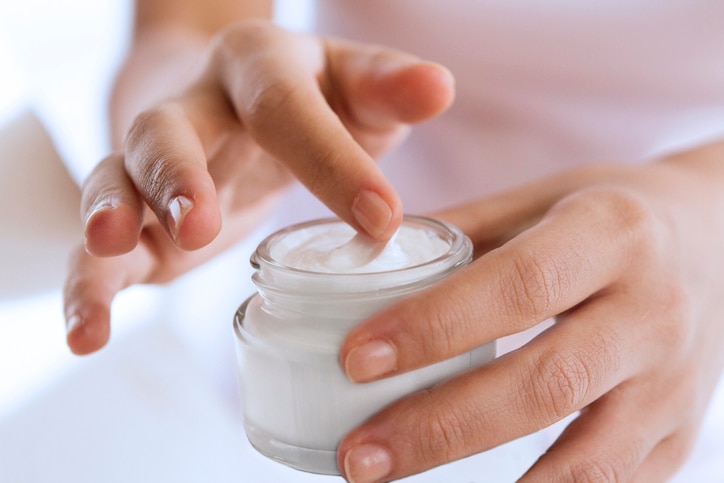 woman's hand touching on the cream for applying