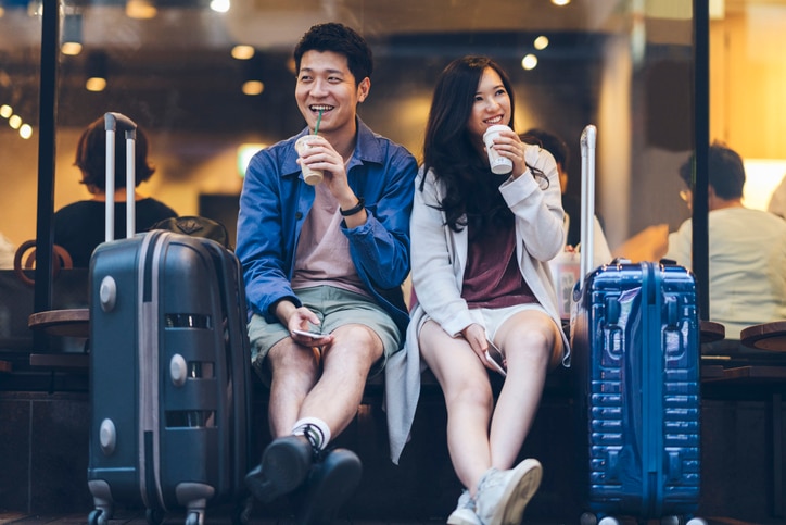 Two Asia tourists are drinking coffee happy in a cafe in their travel destination.