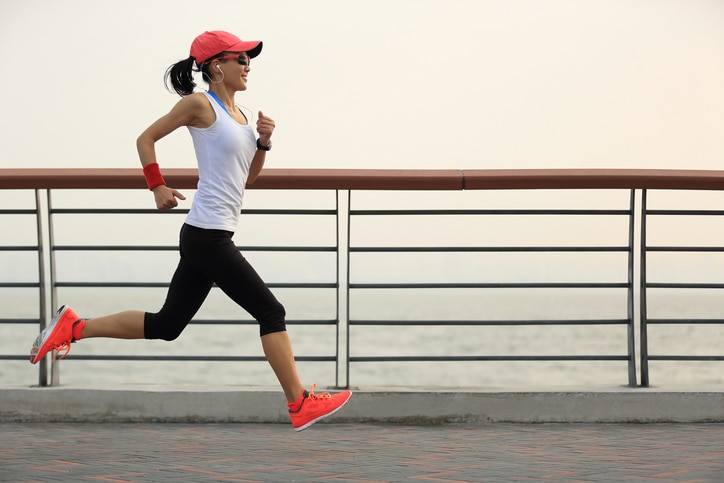 young fitness woman runner running at sunrise seaside