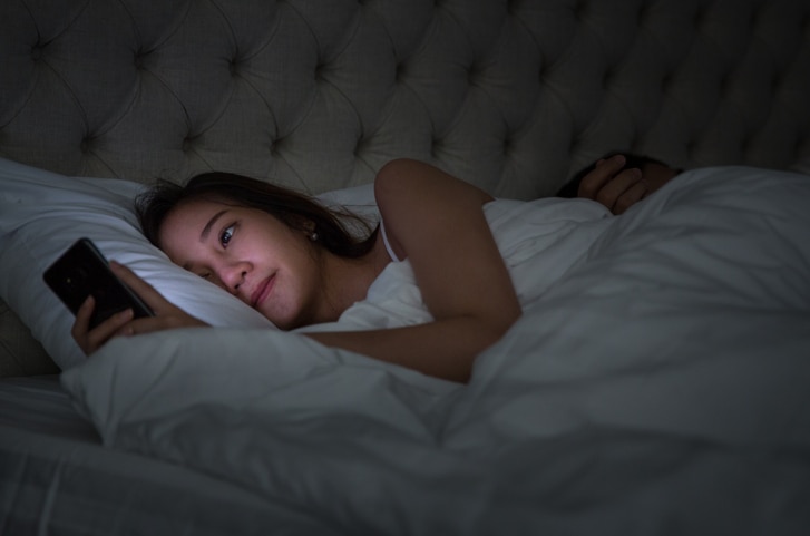 Young Couple On Bed With Smart Phone