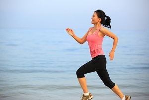 fitness woman running on beach