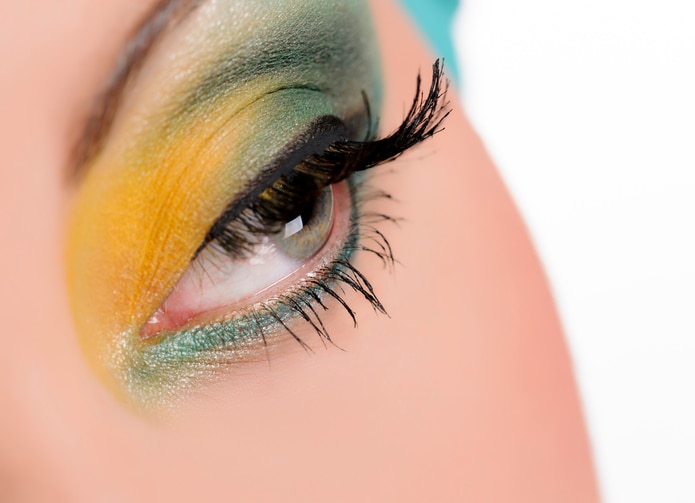 young woman with yellow and green makeup .