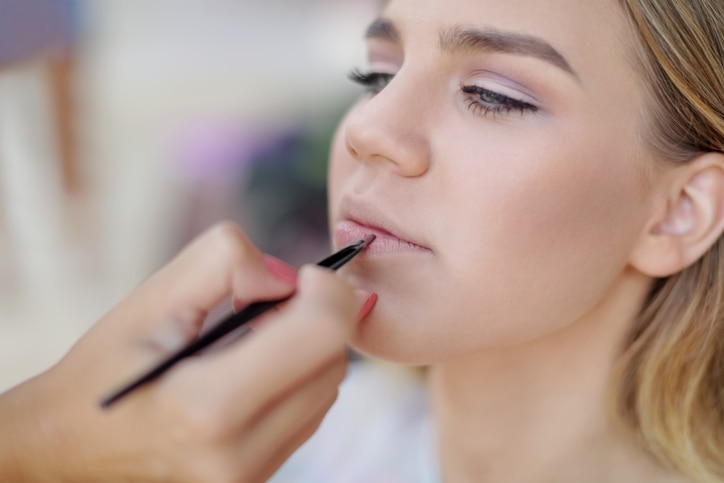 Make-up professional applying lipstick