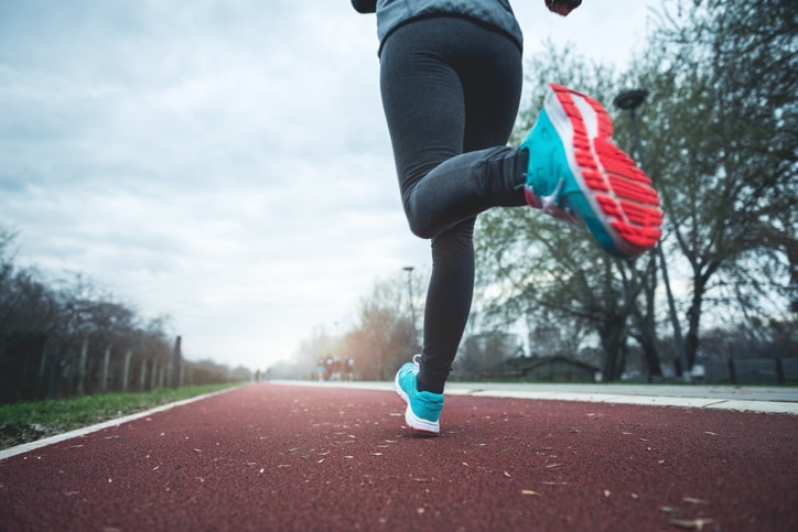 Female legs in a motion running on a road.