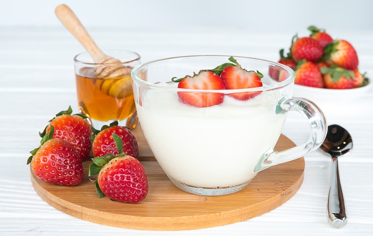 Yogurt strawberry with strawberry fruit and honey on a white background