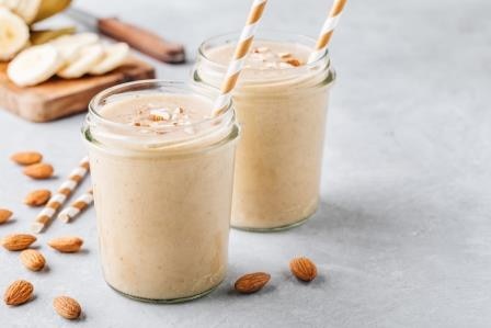 Healthy breakfast. Banana almond smoothie with cinnamon and oat flakes and coconut milk in glass jars