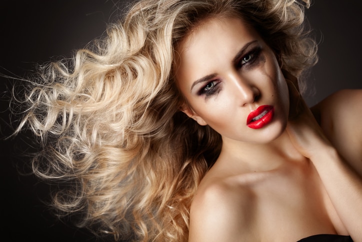 Woman with smeared mascara and red lipstick in a depression