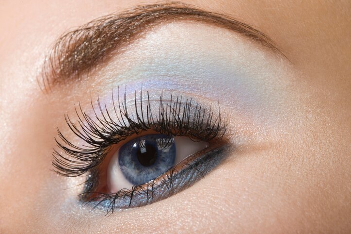 Beautiful woman`s open eye. Light blue and silver eye-shadows.