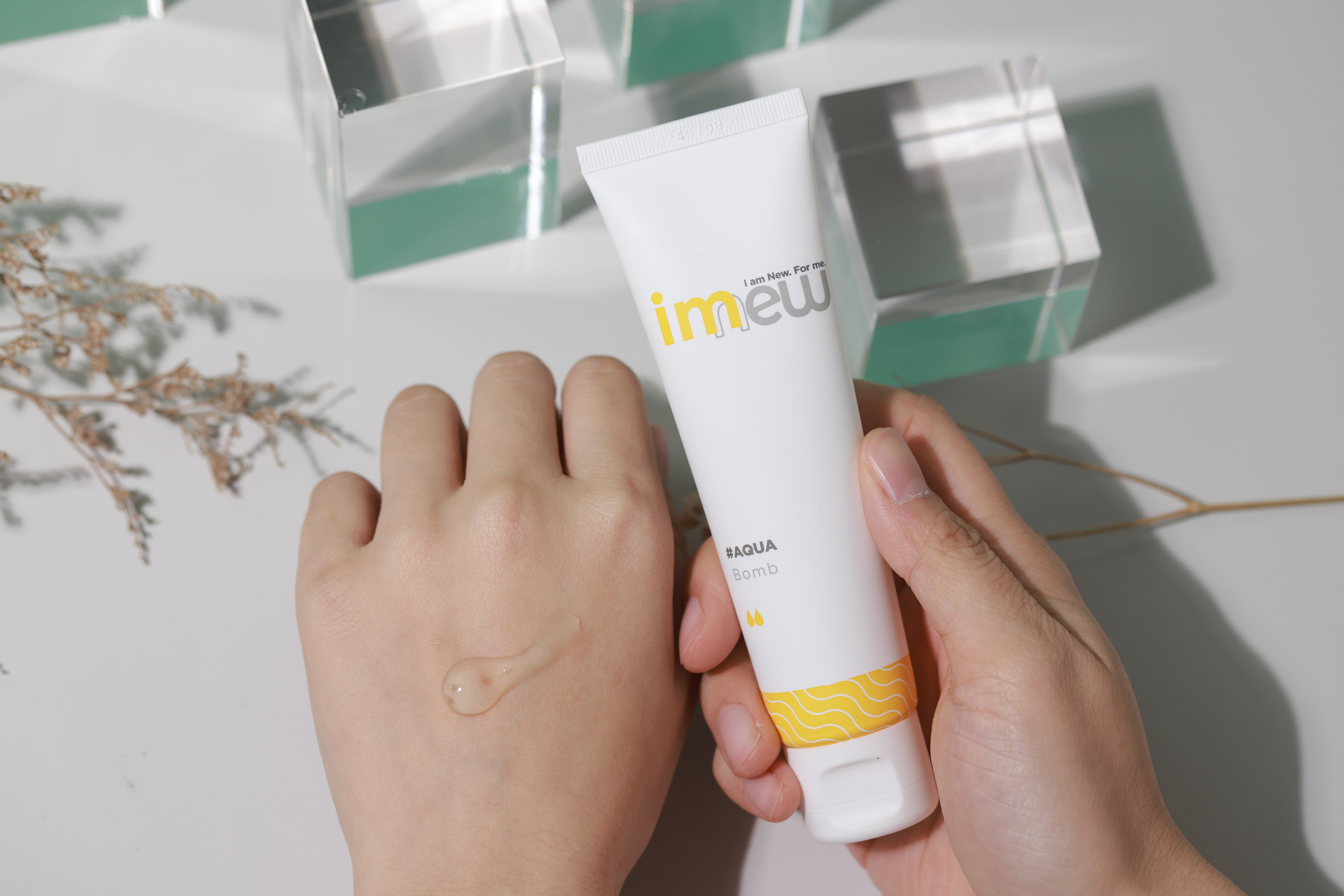 hands with Watsons IMEW Aqua Bomb, skincare product shot